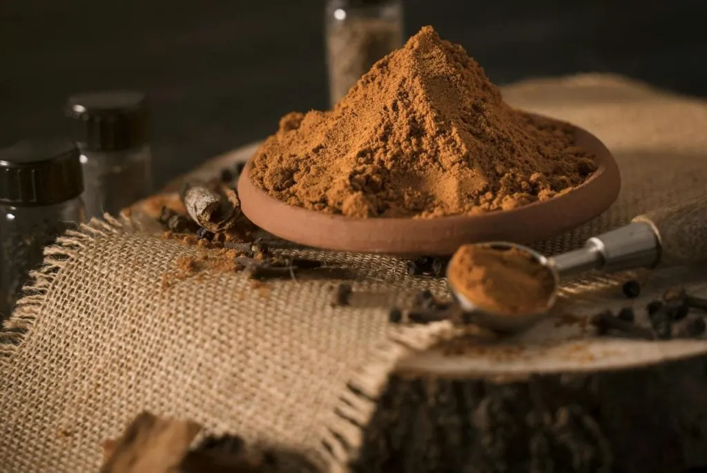 Aesthetic arrangement of spices with cinnamon and cloves in a rustic setting.