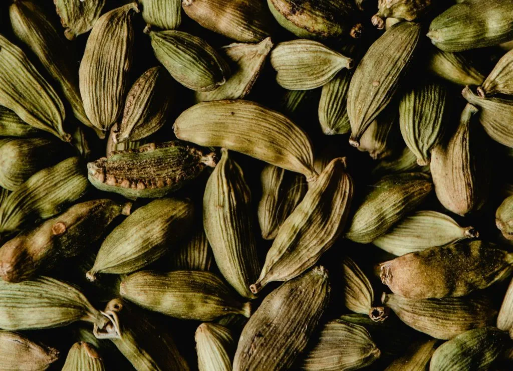 Close-up of vibrant green cardamom pods, ideal for spices and culinary ingredients.