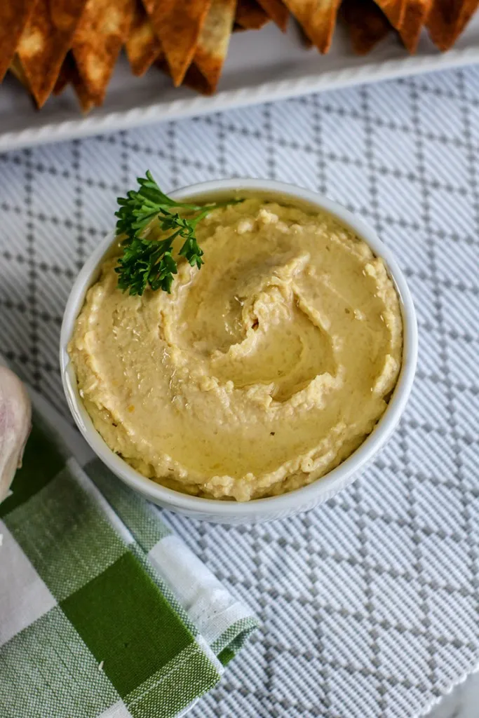 creamy roast garlic instant pot hummus on tablecloth 