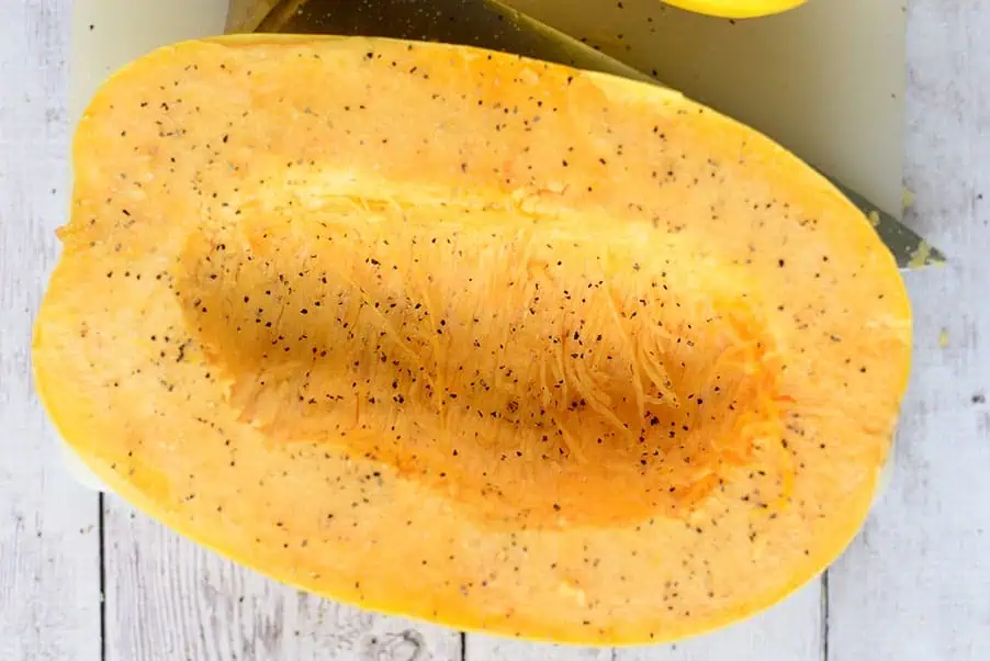 spaghetti squash cut open and seasoned with salt & pepper