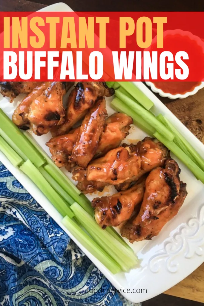 instant pot buffalo wings on a white plate and blue paisley napkin