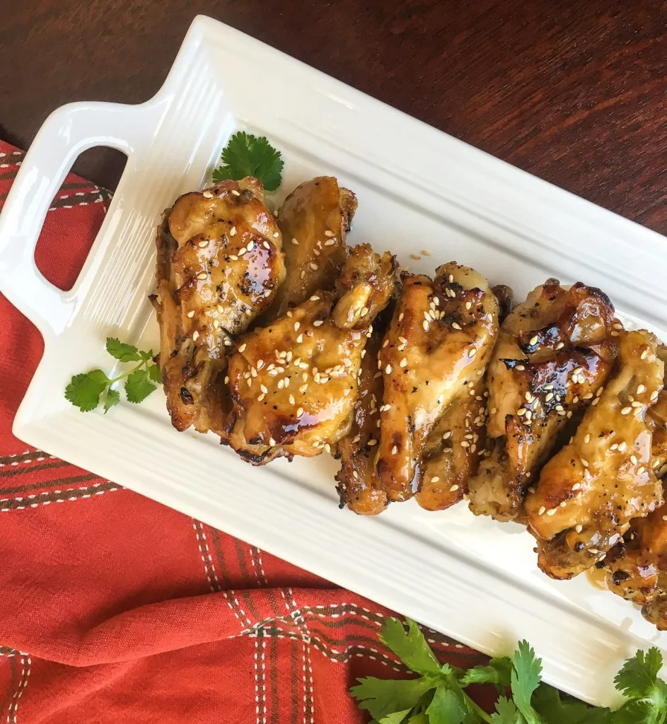 instant pot sesame garlic wings on a white plate with red background