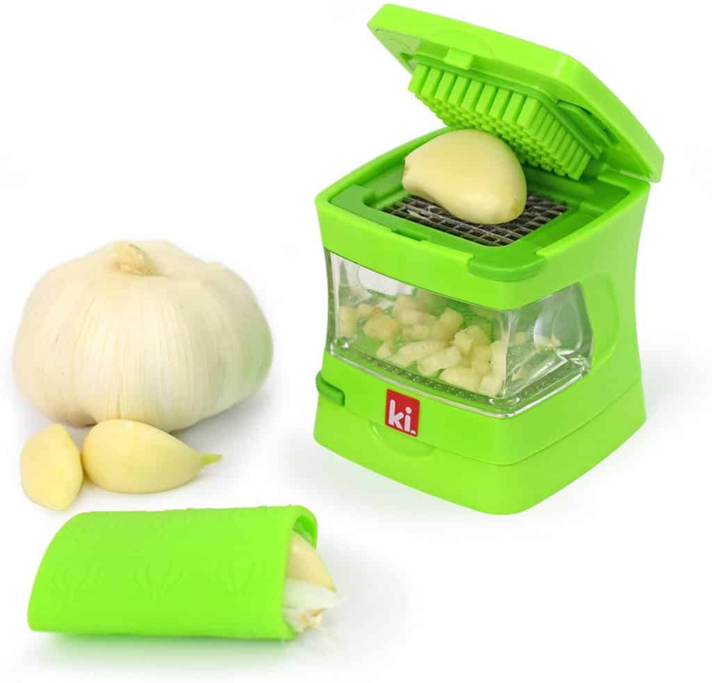 garlic press clever kitchen product in green with huge bulb of garlic