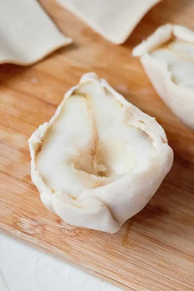 fresh cut pears with pie shell pastry wrapped around the outer pear