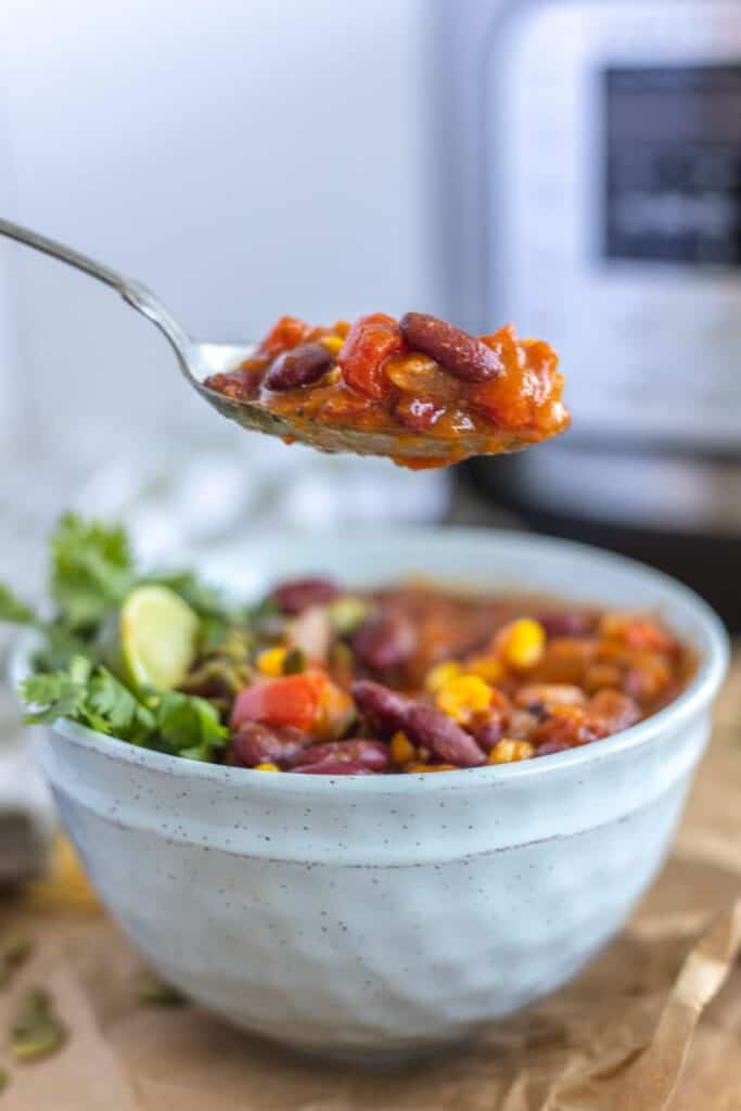 instant put pumpkin chili on a spoon and in a white bowl