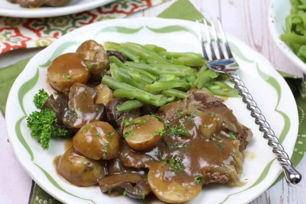 Fork cutting into tender cube steak with rich brown gravy
