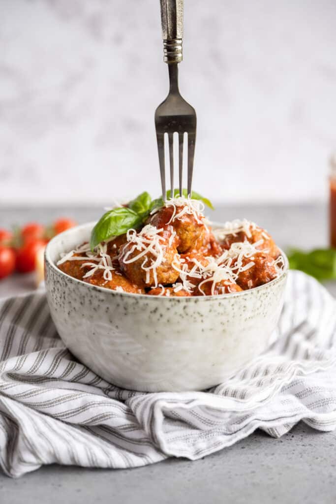 baked keto meatballs in a bowl with a fork stuck in it
