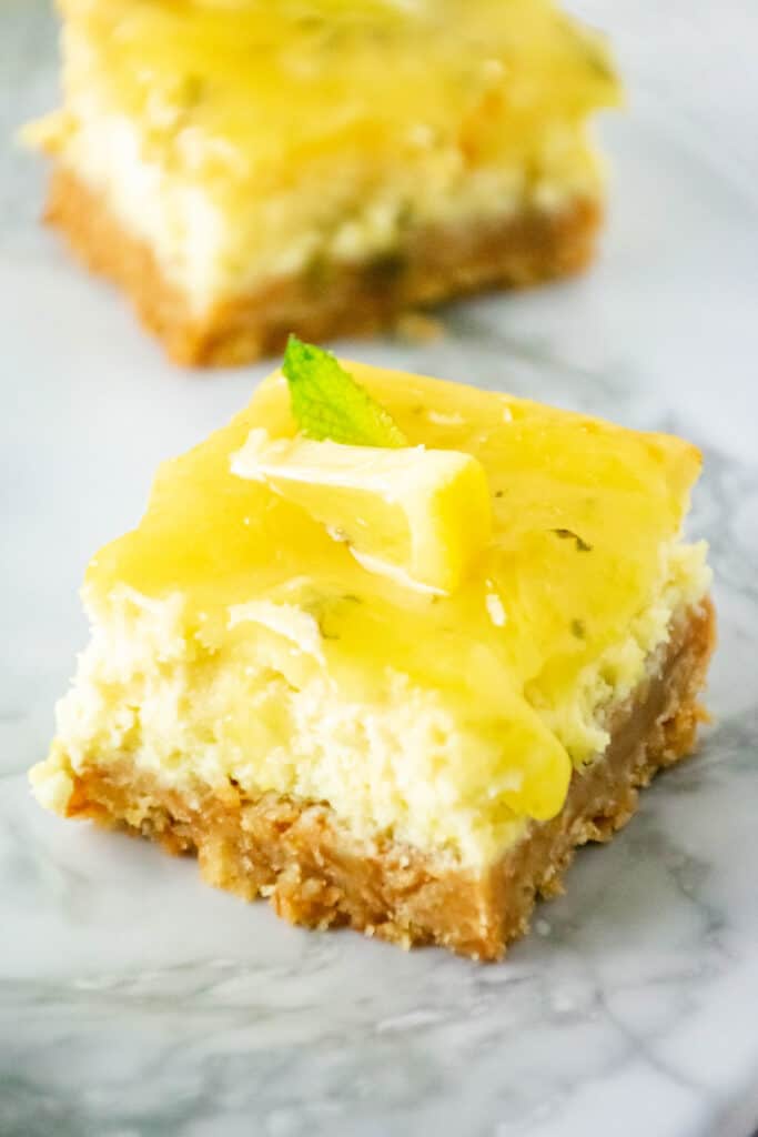lemon wedge on a square piece of lemon cheesecake bar