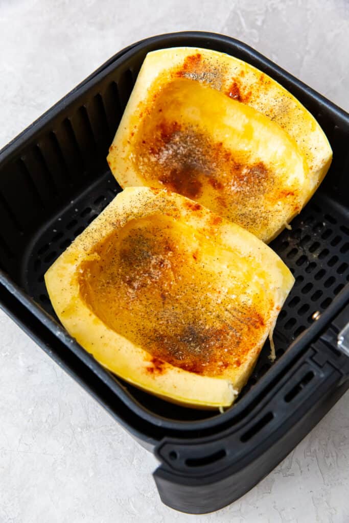 spaghetti squash seasoned and placed in air fryer basket