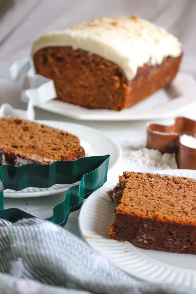 cream cheese icing gingerbread loaf on a white plate