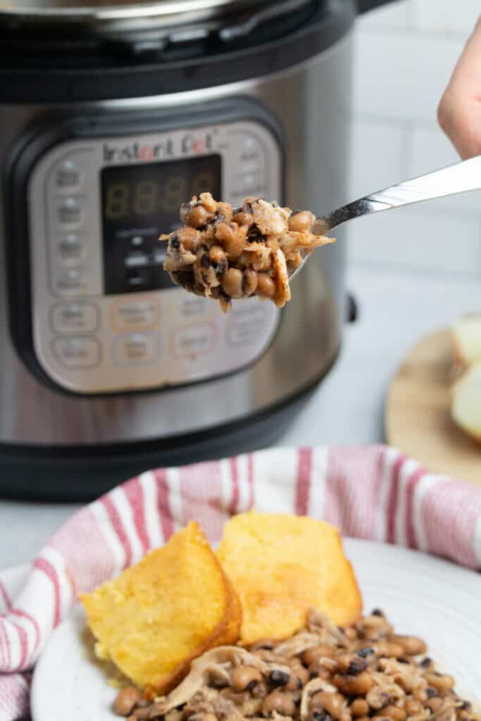 instant pot black eyed peas on a white plate with corn bread