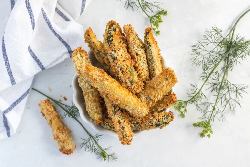 overhead image of stacked fried pickles made in an air fryer with a white and blue napkin