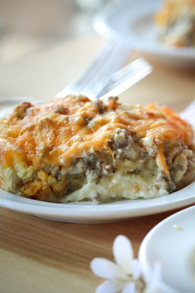 cheesy biscuits with a sausage and gravy casserole recipe on a white plate