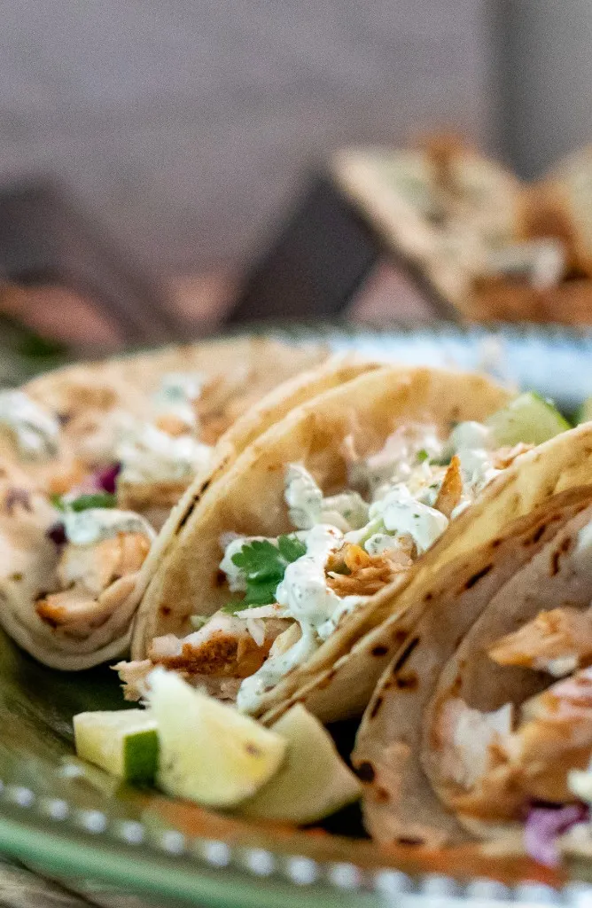 blackened mahi mahi tacos with cilantro on a green plate