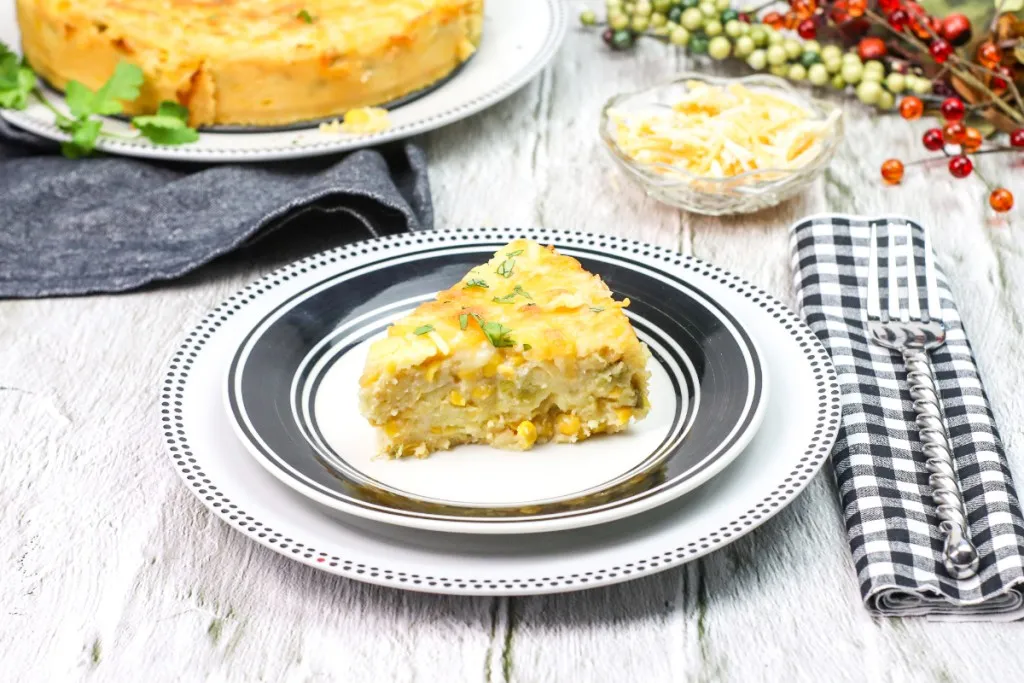 side shot of corn casserole with a black and white checkered napkin on stacked plates