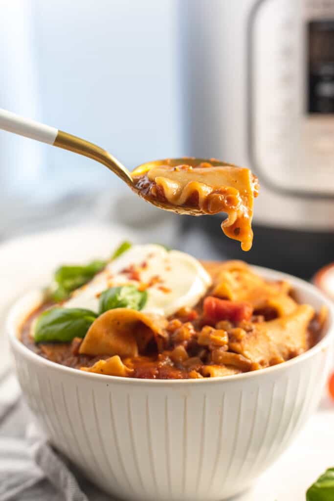 vegetarian instant pot lasagna soup on a spoon and a white bowl