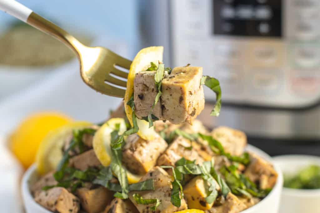 the best lemon tofu recipe on a fork and bowl