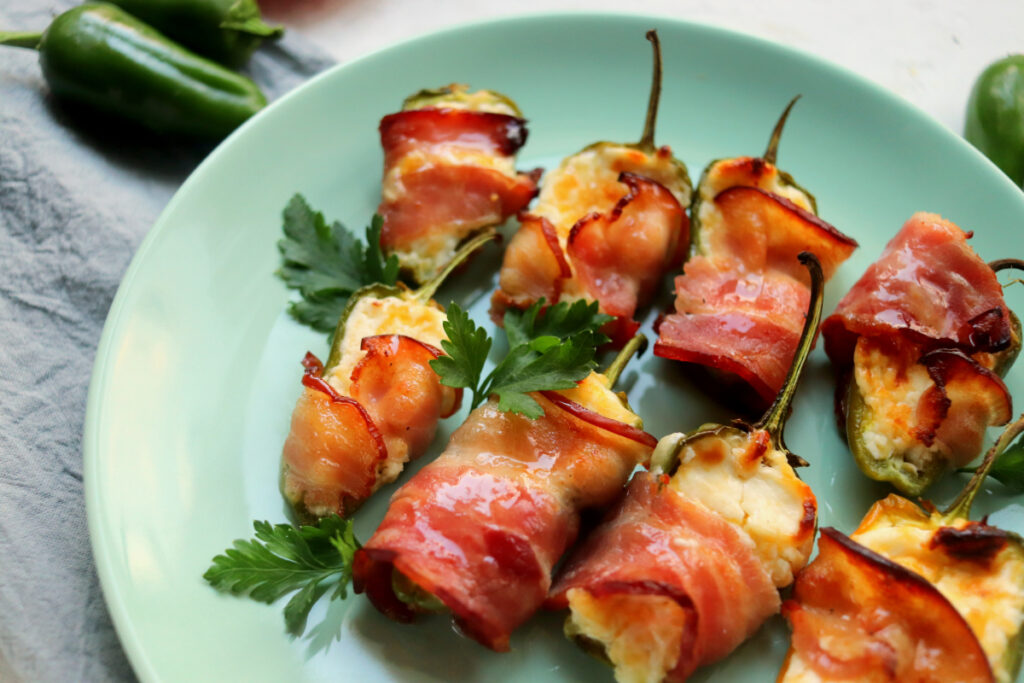 close up shot of bacon wrapped jalapenos and parsley