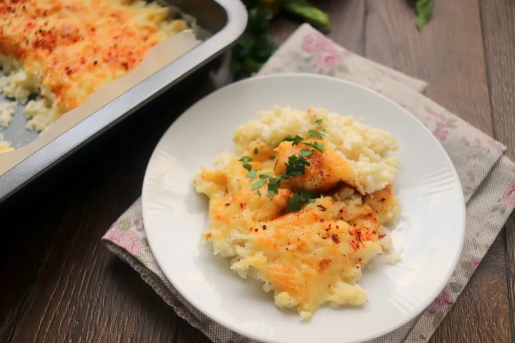 garlic cheddar keto mashed cauliflower on a white plate