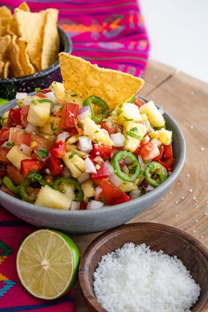 fresh slices of jalapenos in a bowl of pineapple salsa