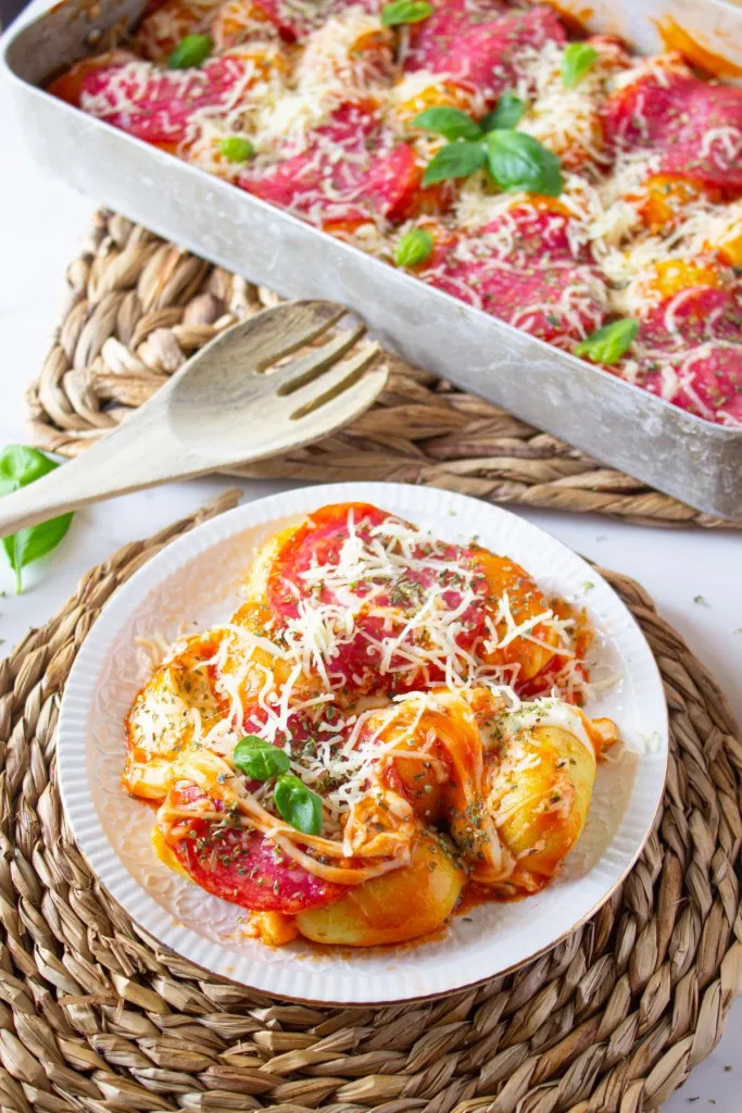 pizza gnocchi casserole on a white plate with shredded parmesan