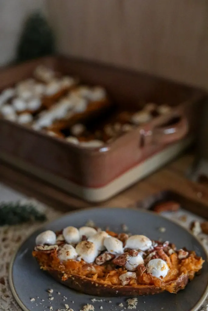 a simple sweet potato with marshmallows and pecans on top