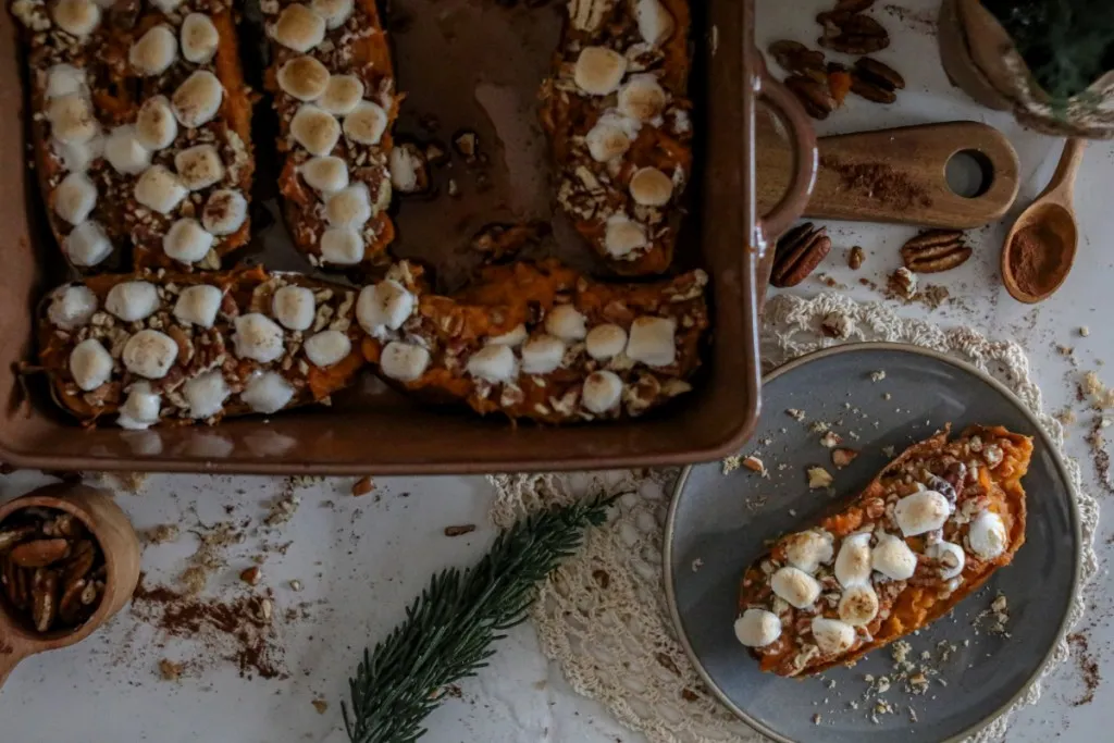 over head shot of twice baked sweet potatoes in a square baking pan topped with marshmallows