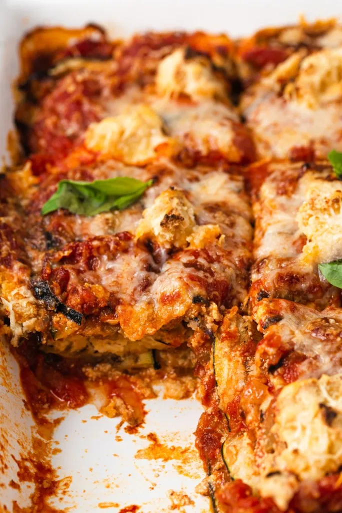 homemade vegan lasagna that has a piece missing