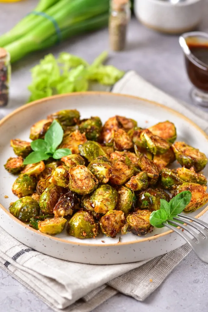 seasoned air fryer brussels sprouts on a stone plate with a fork
