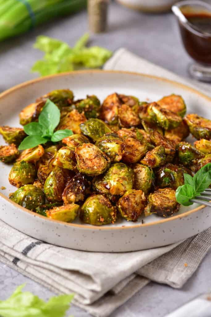 side view of roasted brussels sprouts on a stone colored plate