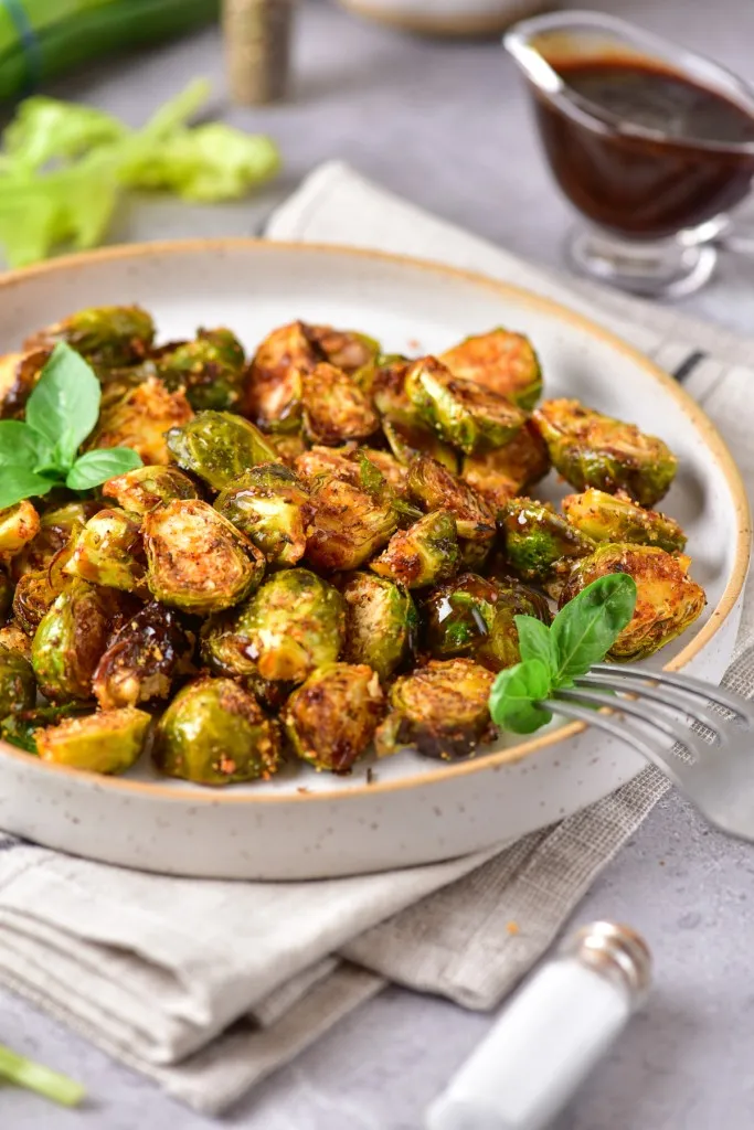 air fryer brussels sprouts on a stone plate with fresh basil
