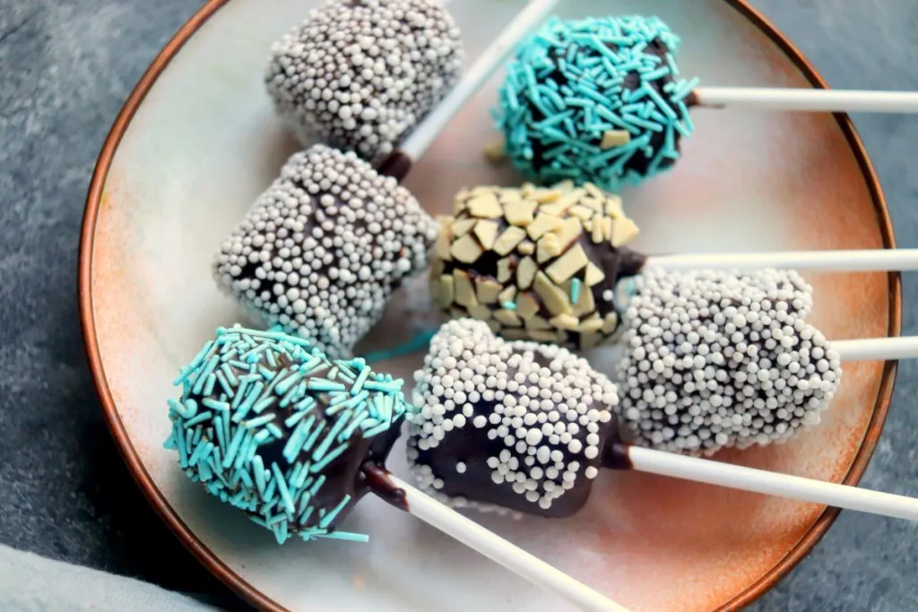 a plate of chocolate covered snowballs with sprinkles
