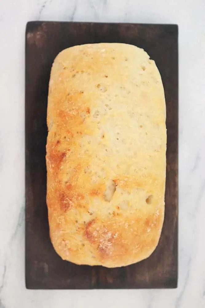 slow cooker 2 ingredient bread toasted in oven on a brown board