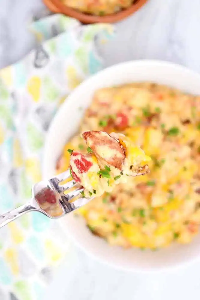 a fork full of cheesy potatoes and smoked sausage