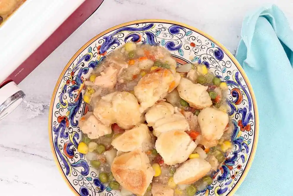 a hearty bowl of chicken pot pie with a blue napkin