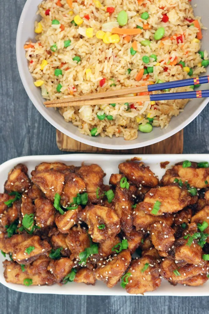 diced green onions and sesame seeds over general tso's chicken made in a crockpot on a white plate