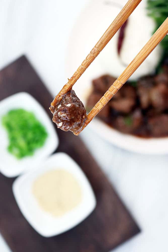 chopsticks holding a piece of korean beef made in a crockpot