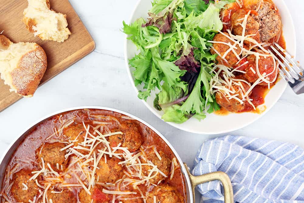 slow cooker meatballs with shredded parmesan cheese and mixed greens