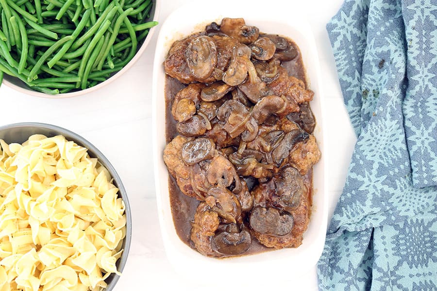 bowl of green beans, buttered pasta, and crockpot salisbury steaks