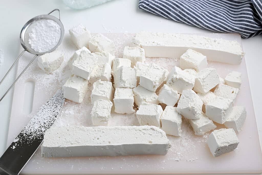 overhead shot of fresh made marshmallows freshly cut on a white cutting board
