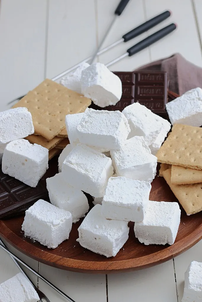 cubes of fresh cut marshmallows on a wooden cutting board