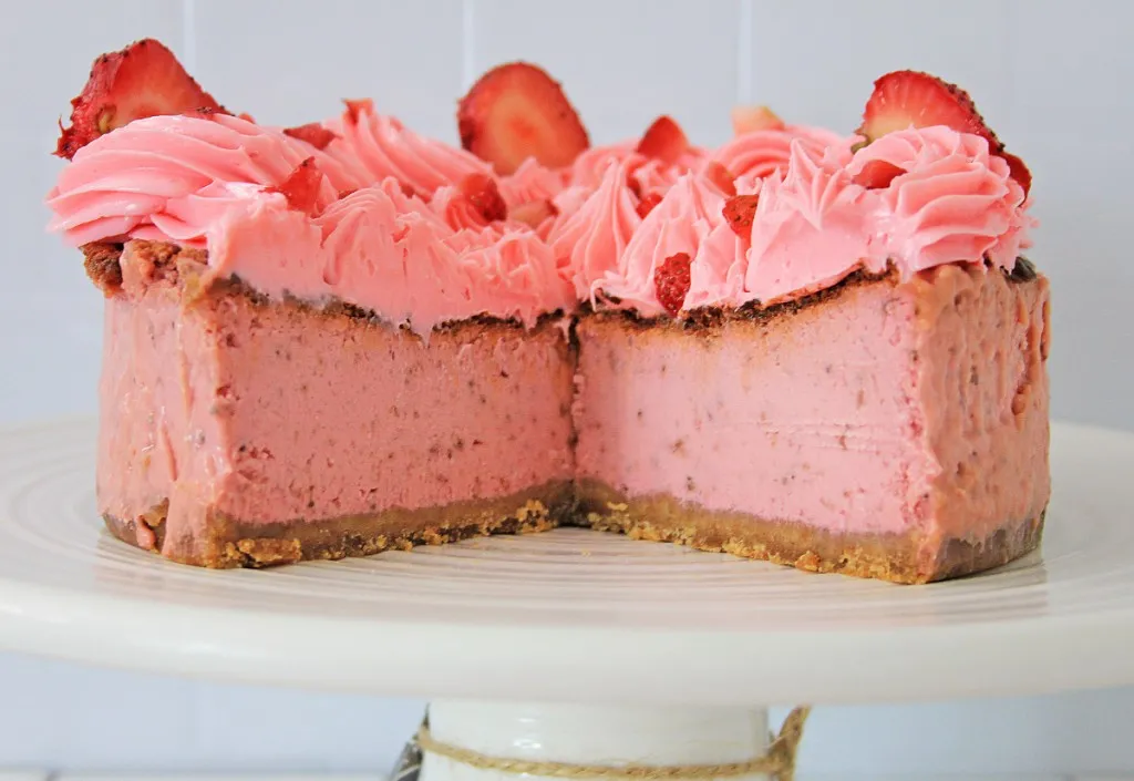 side view of whole air fryer strawberry cheesecake with a slice taken out