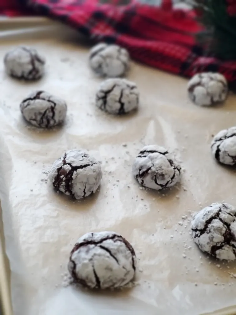 a tray of chocolate crinkle cookies recipe with a tartan towel in the background