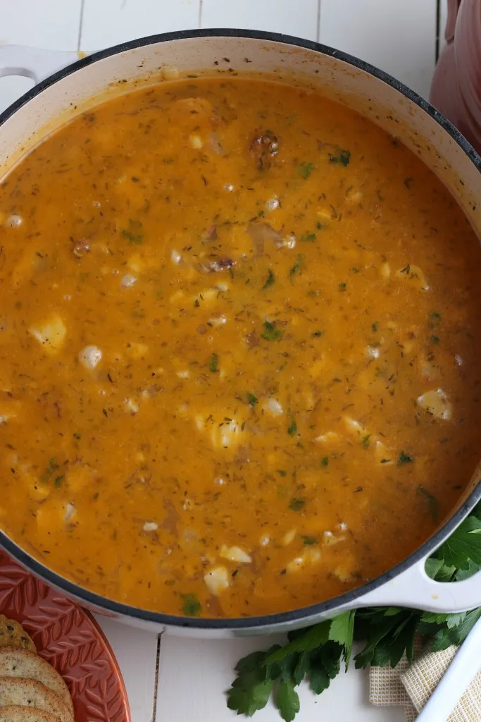 Dutch oven filled with ham and bean soup on a wooden board