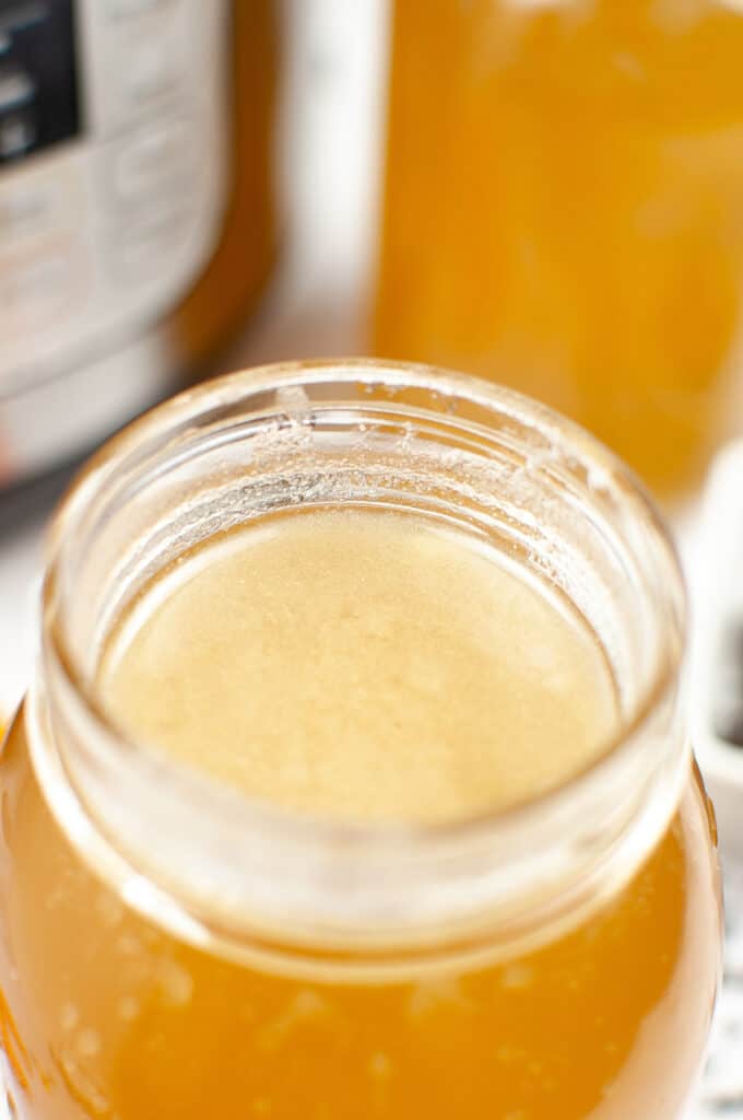 chicken broth in a mason jar next to an instant pot