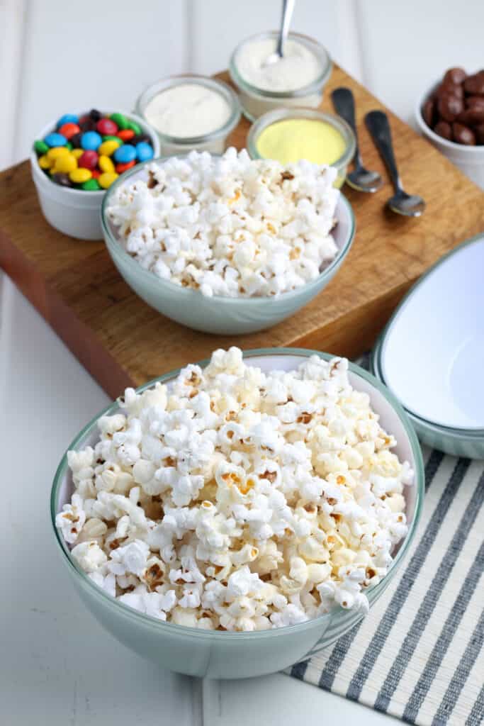 an easy to make popcorn bar with mini m&ms and melted chocolates to drizzle
