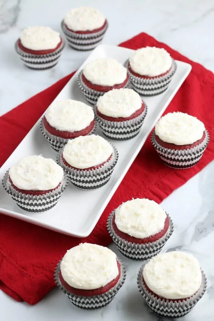 red velvet cupcakes on a granite counter top with a red napkin and white plate