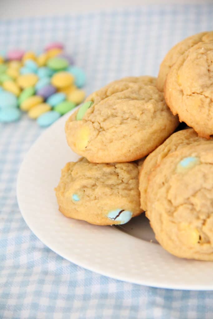 close up view easter m and m cookies on a white plate with a pastel blue plaid napkin
