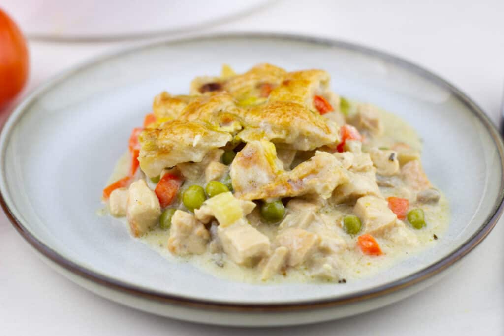 side view of a serving of easy chicken pot pie recipe on a stoneware style plate