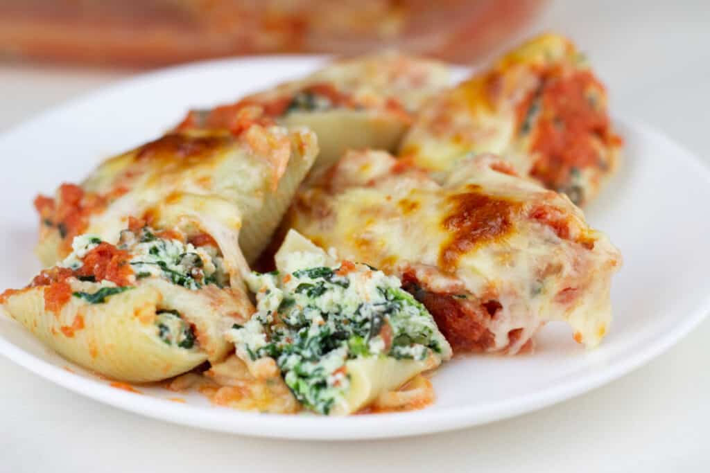 spinach and ricotta cheese stuffed shells with baked mozzarella cheese on top